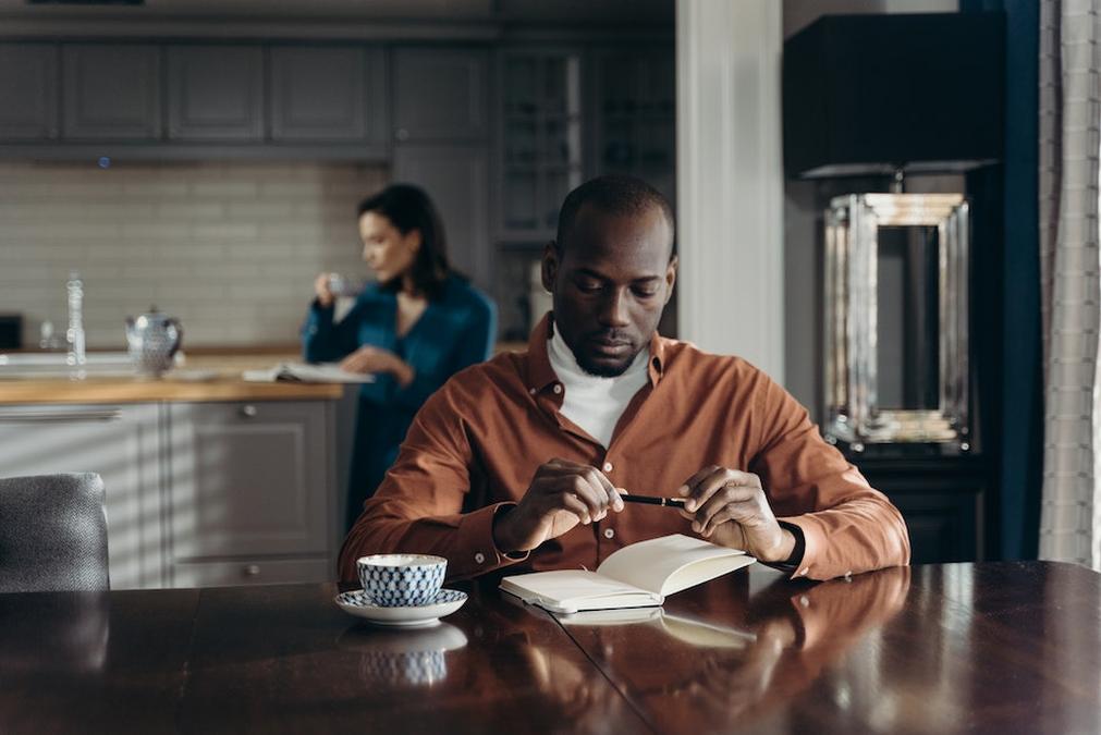A Man and Woman Reading Book while Having a Cup of Coffee